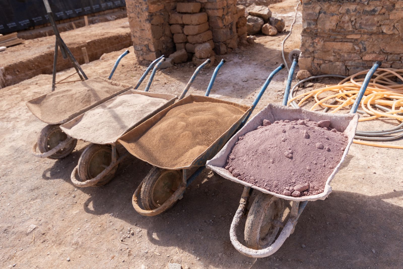 Brouettes de terres et de sables de différentes couleurs pour les mélanges